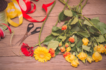 Workplace of florist, making bouquet. Yellow and orange roses on