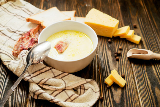 
cheese soup with smoked pork ribs , potatoes, carrots , peppers , spices and bread on the wooden background