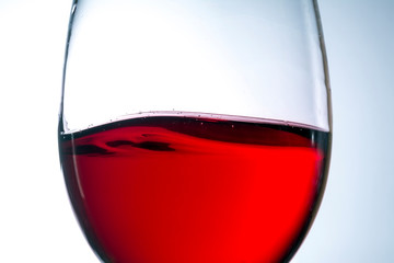 red wine in glass, splashing, splash, wave of red wine close up
