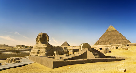 Fototapeta na wymiar Egypt. Cairo - Giza. The Sphinx, the Pyramid of Khafre (Chephren) and Menkaure (Mykerinos) in background. The Pyramid Fields from Giza to Dahshur is on UNESCO World Heritage List