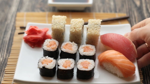 Waiter puts a plate with sushi on the table