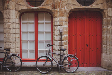 Fototapeta na wymiar bicycles near brick wall and red door