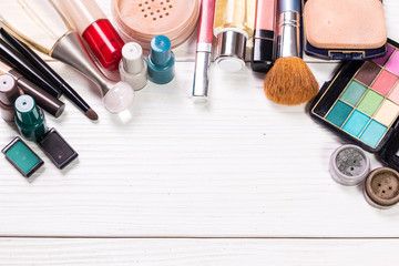 Various makeup products on dark background with copyspace