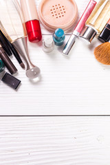 Various makeup products on dark background with copyspace