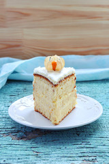 piece of homemade cake decorated with winter cherry on a blue ba