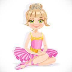 Beautiful ballerina girl in purple dress and tiara sit on floor