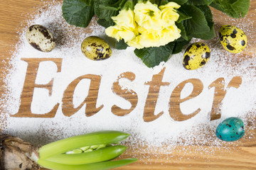 inscription Easter with eggs and yellow primrose flowers