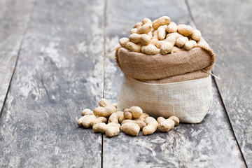 fresh  monkeynut in sack bag on wooden background