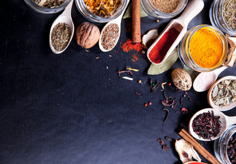 Spices on black background in special jars. Food