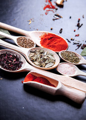 spice in wood spoon on a black background. food