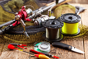 fishing tackle on a wooden table. toned image