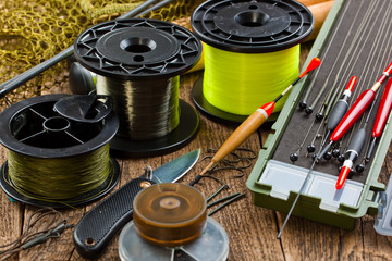 fishing tackle on a wooden table. toned image