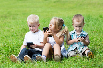 Naklejka na ściany i meble Happy kids playing on smartphones