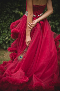 beautiful girl in a long dress in the garden. Peacock feather