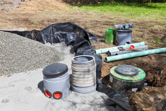 Filter and pump installation on a new septic tank in a sand and gravel filter bed with plastic liner for treatment of household sewage and wastewater