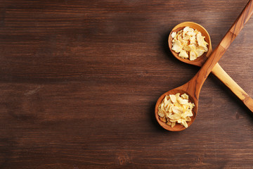 Two wooden spoons with almond flakes on the table, close-up