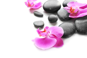 Obraz na płótnie Canvas Black spa stones and orchids isolated on white