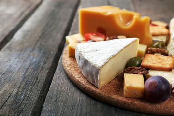 Fototapeta na wymiar Different kinds of cheese on wooden background