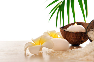 Obraz na płótnie Canvas Spa concept of plumeria, coconut and candles with sea salt, isolated on white