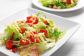 Tasty salmon salad on wooden table background