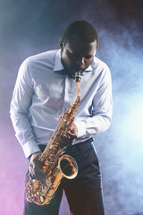 Plakat African American jazz musician playing the saxophone against colorful smoky background