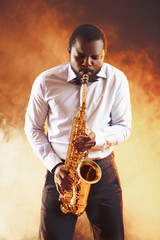 Fototapeta na wymiar African American jazz musician playing the saxophone on ginger background