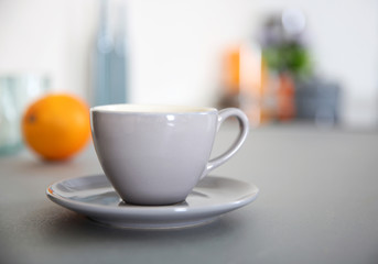 Cup of coffee on the table against unfocused background