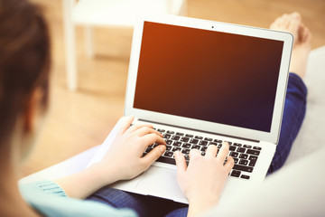 Woman sitting on sofa with a laptop in a room