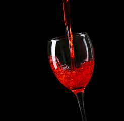 Wine pouring in glass on black background