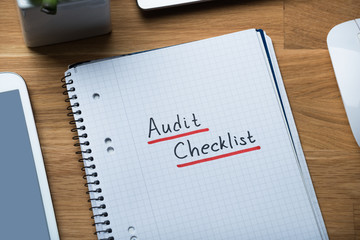 Audit Checklist Written On Notepad At Office Desk