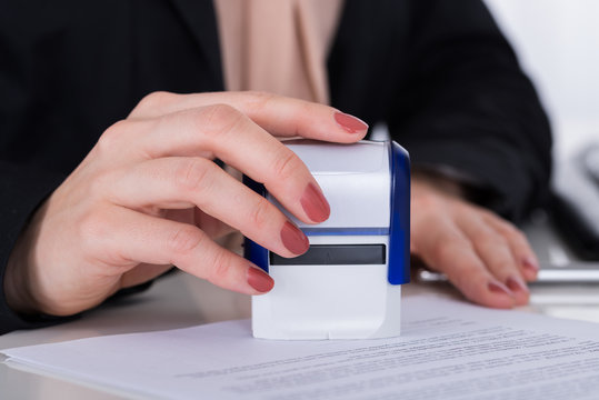 Businessperson Using Stamper On Document