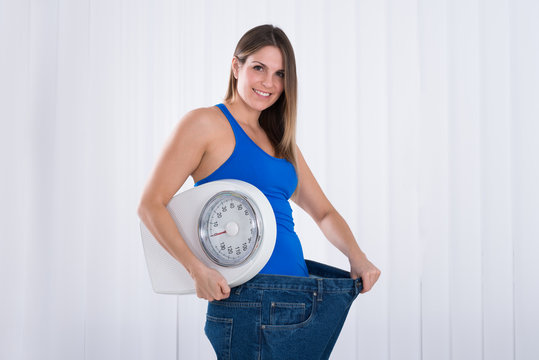 Woman With Weighing Machine Wearing Big Jeans