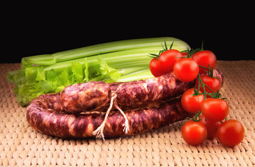 Smoked sausage with  celery and  a bunch of small red tomatoes