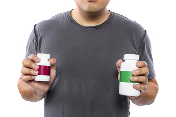 Male comparing bottles of medicine or dietary supplements