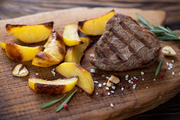 Grilled beef filet mignon steak with roasted potato slices