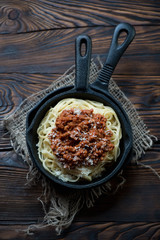 Above view of spaghetti bolognese in a rustic wooden setting