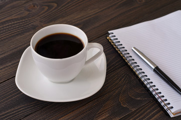 American cup of coffee with notebook and pen
