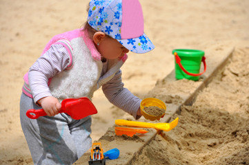 The little child playing in the sandbox
