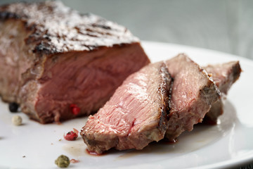 sliced beef steak on white plate close up