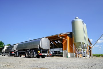 Obraz premium Milchwagen mit Anhänger vor einem neuen Kuhstall