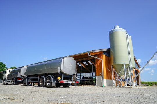 Milchwagen mit Anh&auml;nger vor einem neuen Kuhstall
