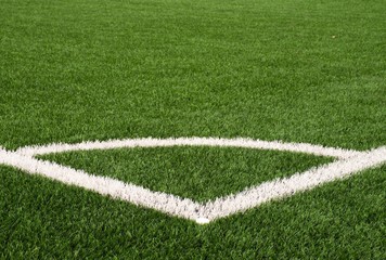 Obraz premium Football playground corner on artificial green turf ground with painted white line marks. Milled black rubber in basic.