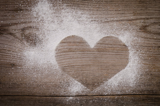 mark in the shape of a heart with powdered sugar  on wooden back
