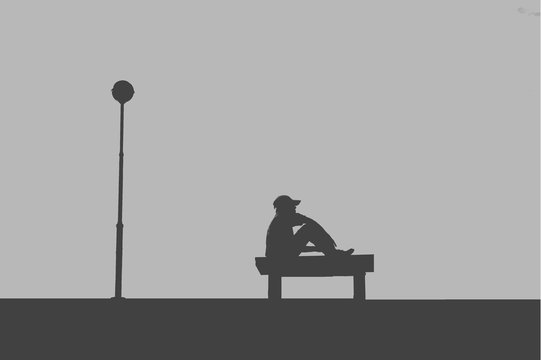The silhouette of man sitting alone with grey sky, concept of lonely, sad, alone, person space