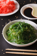 Wakame seaweed salad with sesame seeds on a table. Vertical
