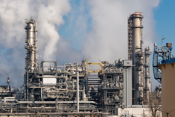 Fototapeta na wymiar detail of smoking chimneys of a petrochemical factory in an oil refinery