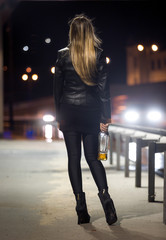 Rear view of woman posing at highway at night