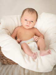 Toned portrait of 2 month old baby sitting in basket covered by