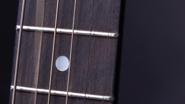 String of acoustic guitar, second string, on black, close up, slow motion