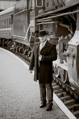 Obraz na płótnie Canvas retro photo of elegant man waiting on platform for train